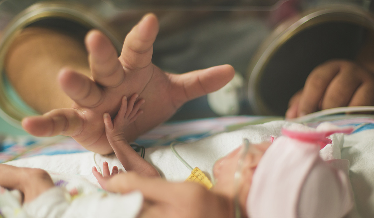 A parent and NICU baby High Five!